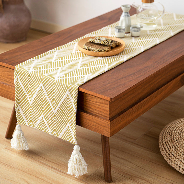 Woven table runner with geometric herringbone diamond pattern and decorative tassels