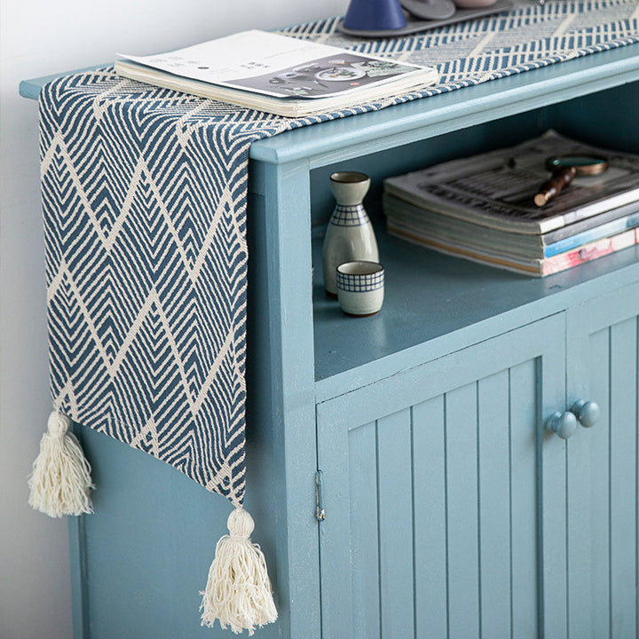 Woven table runner with geometric herringbone diamond pattern and decorative tassels
