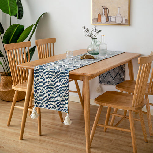 Woven table runner with geometric herringbone diamond pattern and decorative tassels