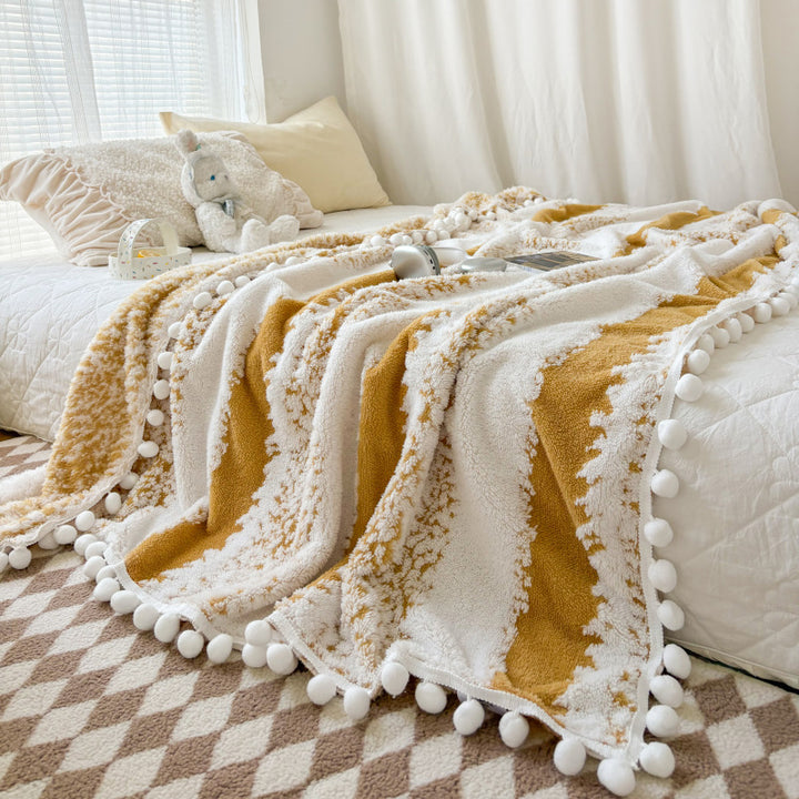Structured throw blanket with pom-pom details