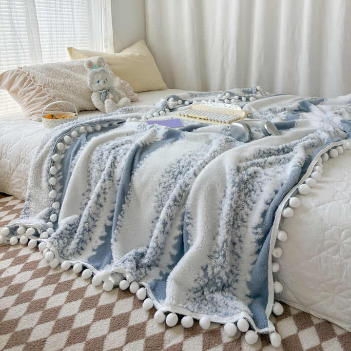 Structured throw blanket with pom-pom details