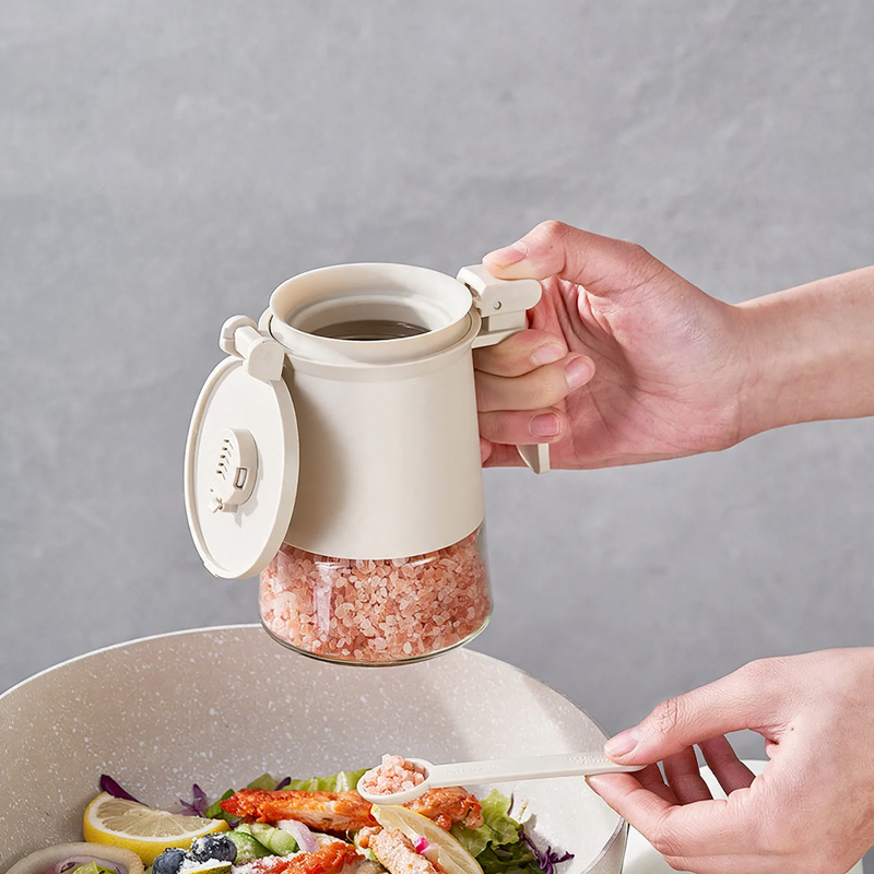 Sealed spice container made of glass with spoon