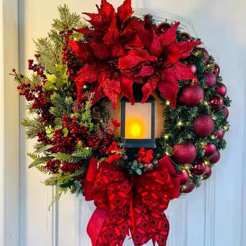 Christmas wreath with decorative lantern and red flowers