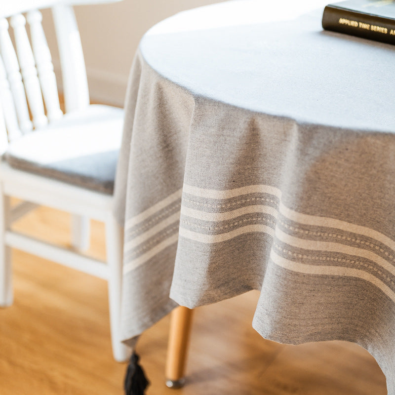 Rectangular tablecloth made of cotton-linen blend with subtle striped border and decorative tassels