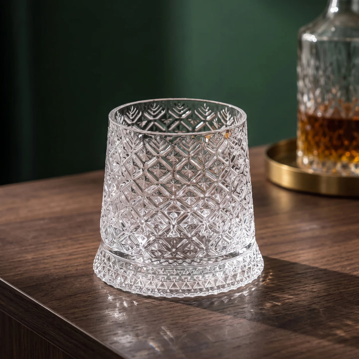Ice flower crystal spinning whiskey glass on a walnut sideboard