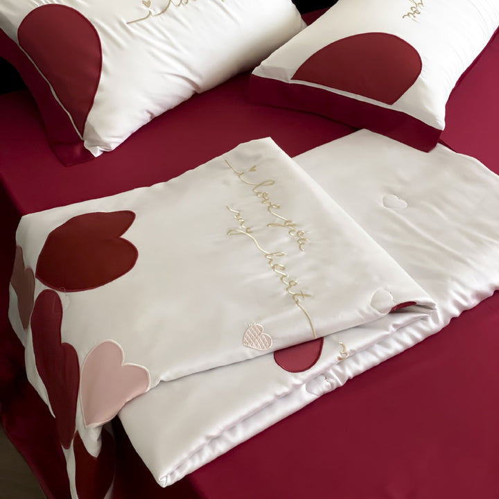 Bedding set with quilted heart appliqués and satin border