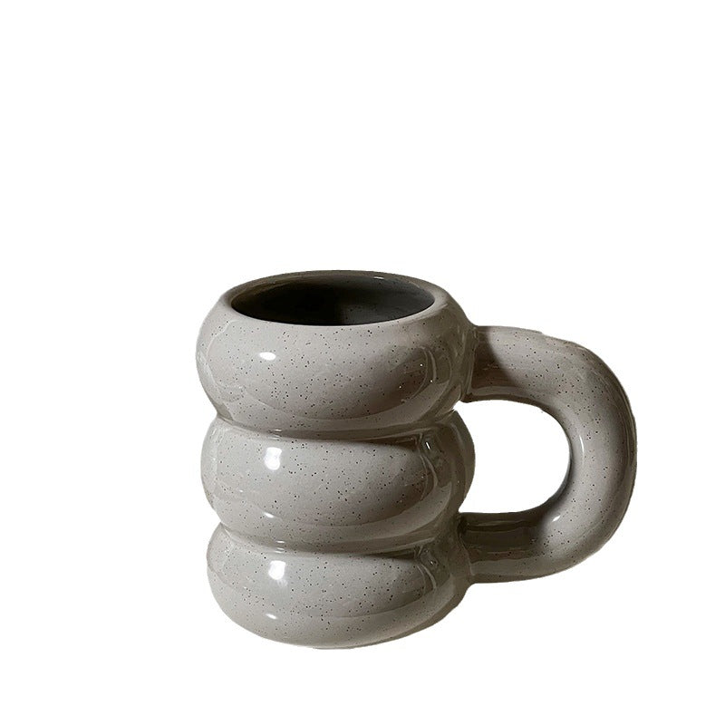 Sculptural ceramic coffee mug with stacked ring body and ergonomic handle