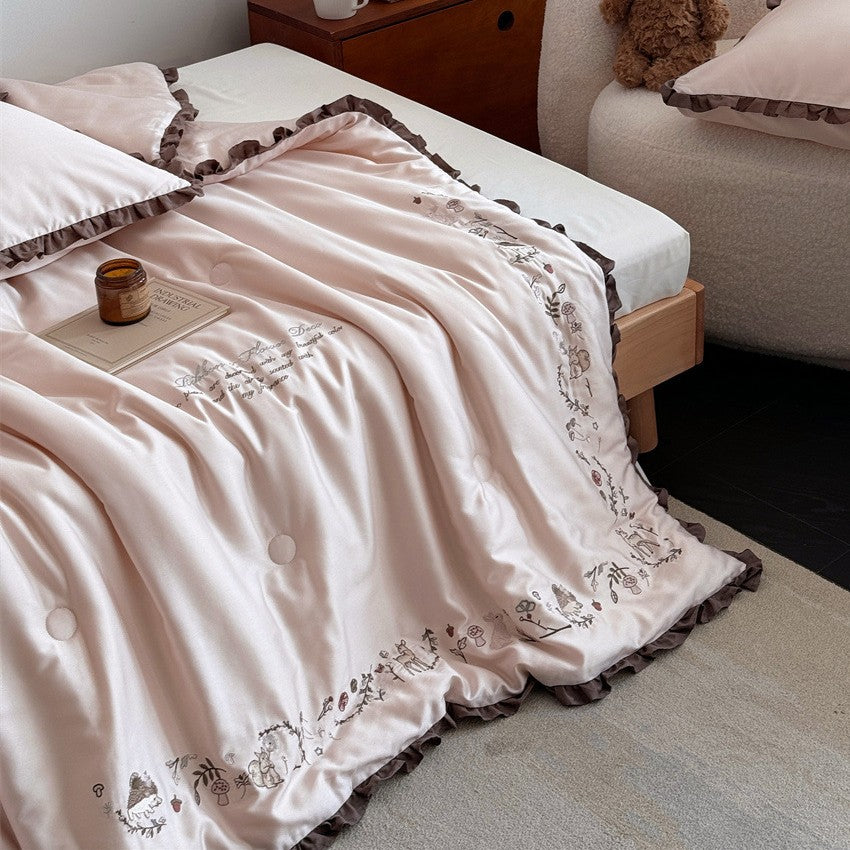 Quilted reversible duvet cover with floral embroidery and ruffled hem