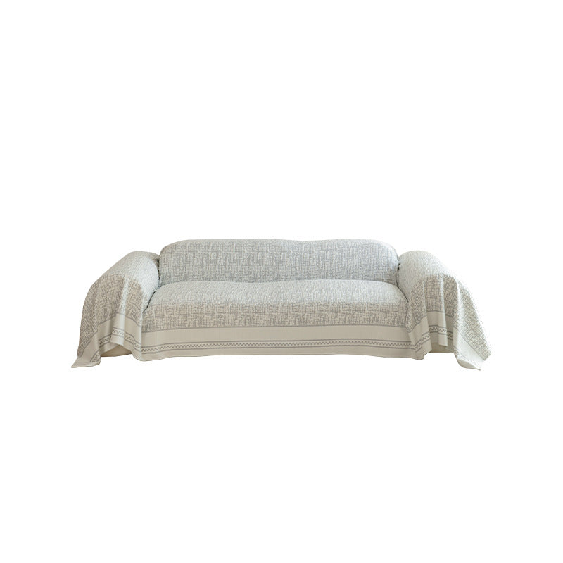 Geometric sofa cover made of cotton blend fabric with decorative fringe edge