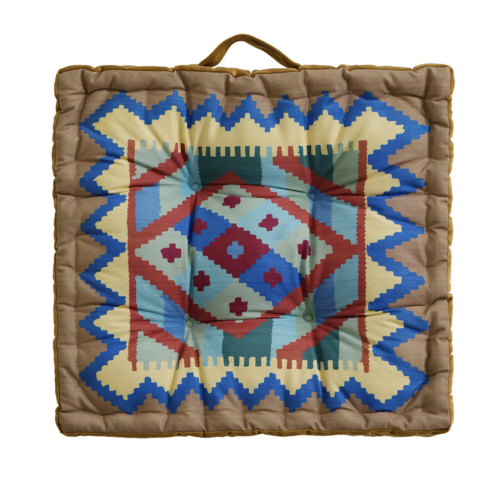 Square seat cushion with kilim-inspired pattern, quilted padding and carrying handle