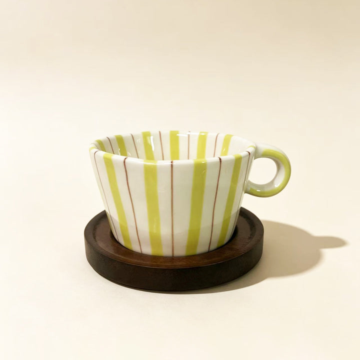 Ceramic espresso cup with round wooden coaster and handcrafted stripe pattern