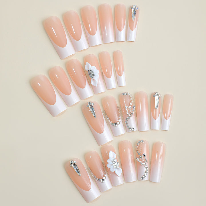 Artificial nail set with elegant French tips and glamorous embellishments Bowlift