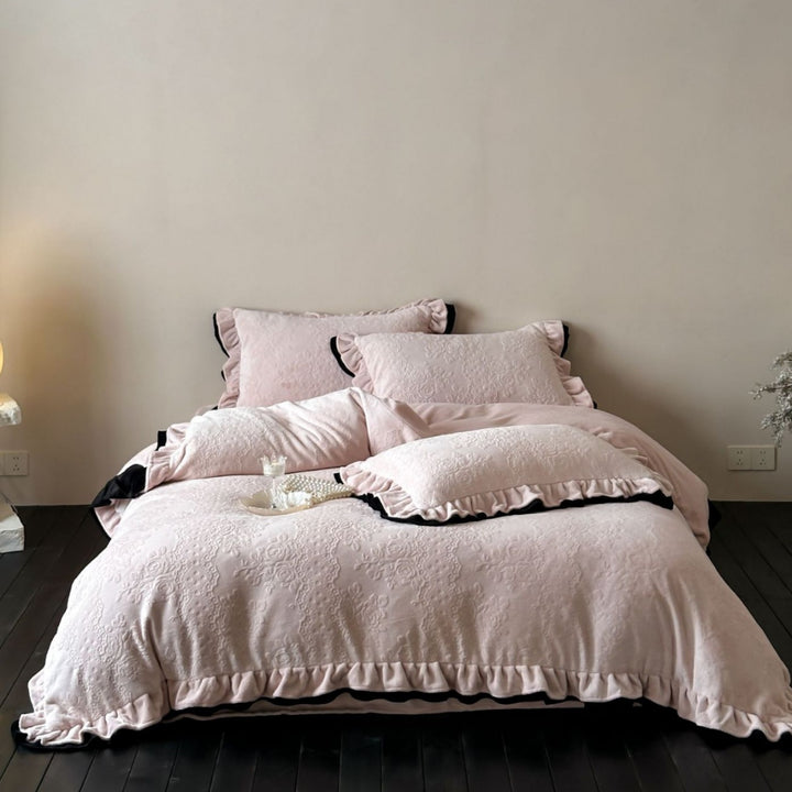 Quilted bedding set with floral embossing and ruffled frills