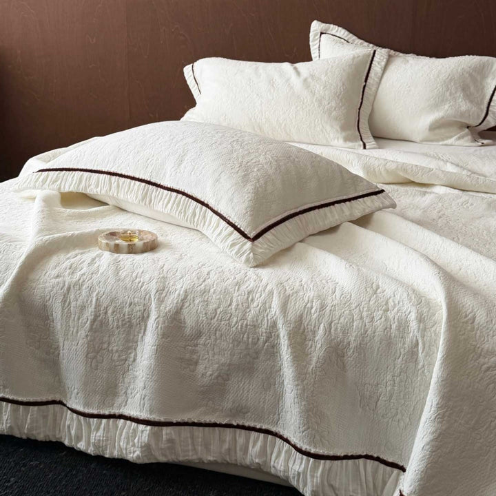 Quilted bedspread and pillowcase set with ruffle and fine piping