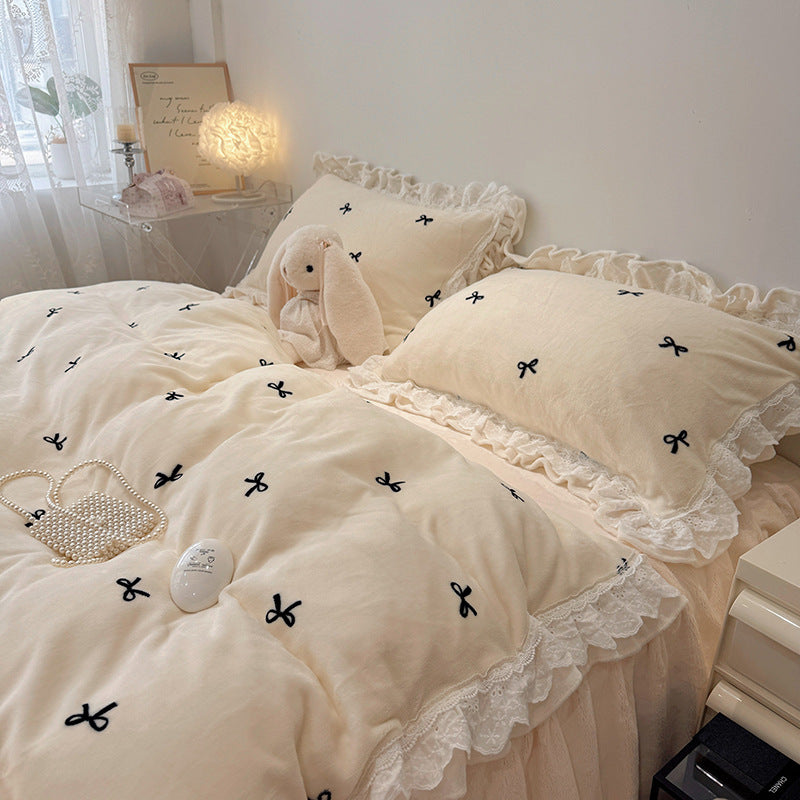 Bedding set with ruffled border and embroidered bows