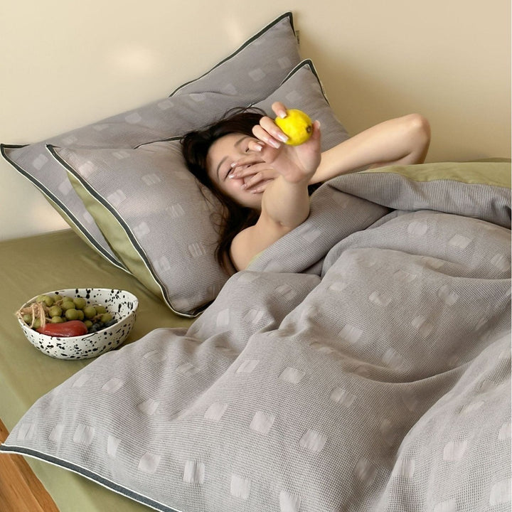 Reversible cotton bedding set with subtle square structure and contrast piping