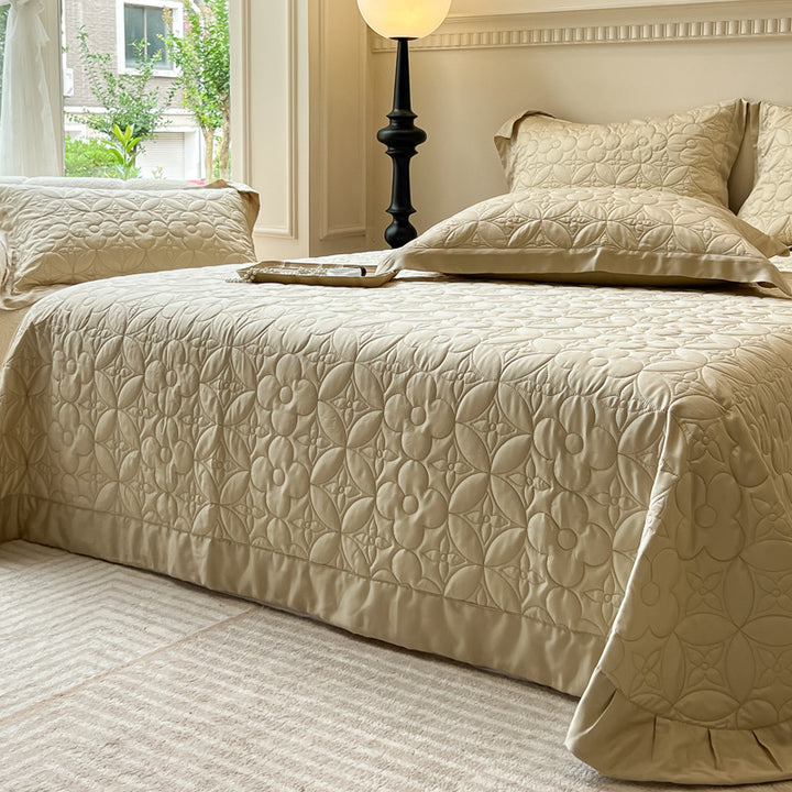 Quilt-bedspread set with embossed floral relief and neck roll