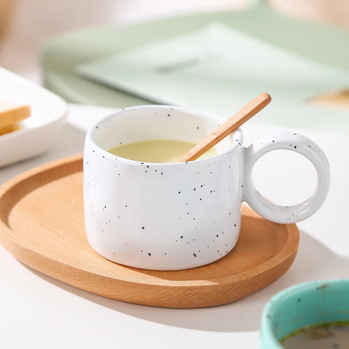 Ceramic mug with heart-shaped handle and speckle design